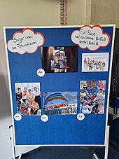 Gewinnerfotos an einer blauen Pinnwand.