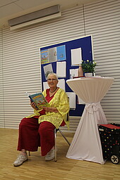 Frau liest aus Kinderbuch vor
