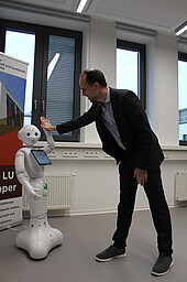 Roboter und Minister klatschen sich ab
