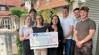 Studierende mit Spendenscheck