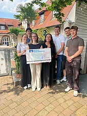 Studierende mit Spendenscheck