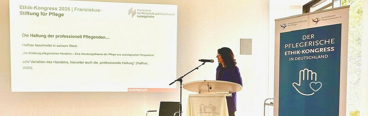 250606_Seiler_Ethikkongress Frau an Rednerpult in Vortragssaal