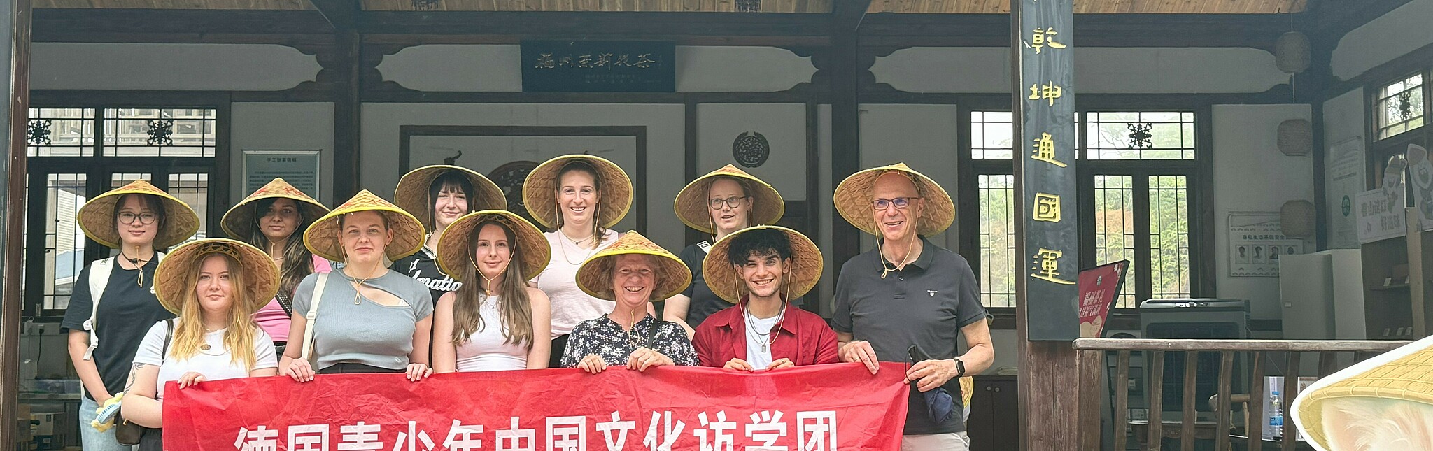 Gruppenbild der Jugenddelegation mit asiatischen Hüten vor Tempel
