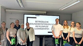 Personengruppe vor großem Präsentationsbildschirm